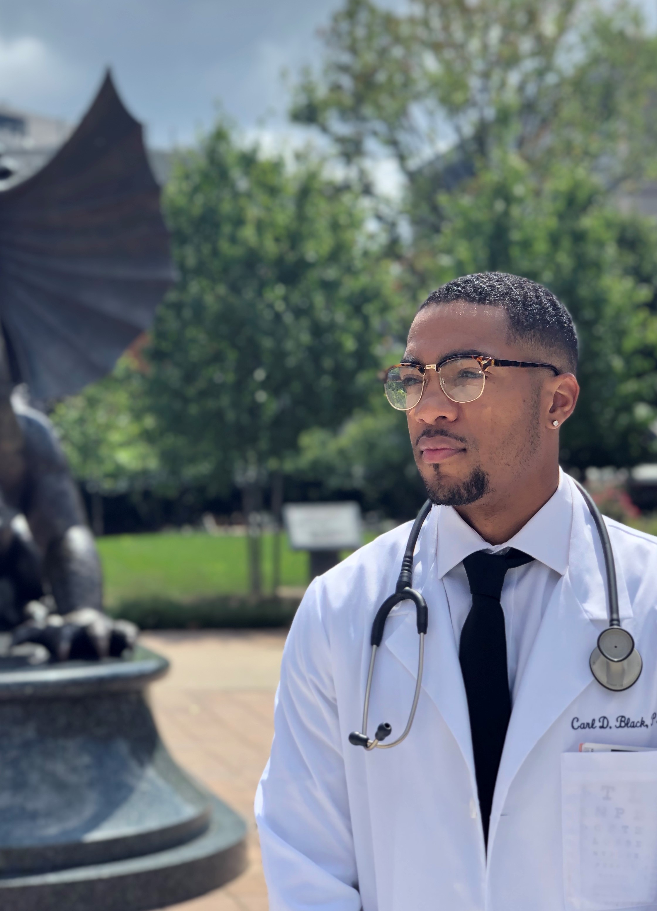 Carl Black wears white coat with stethoscope around his neck